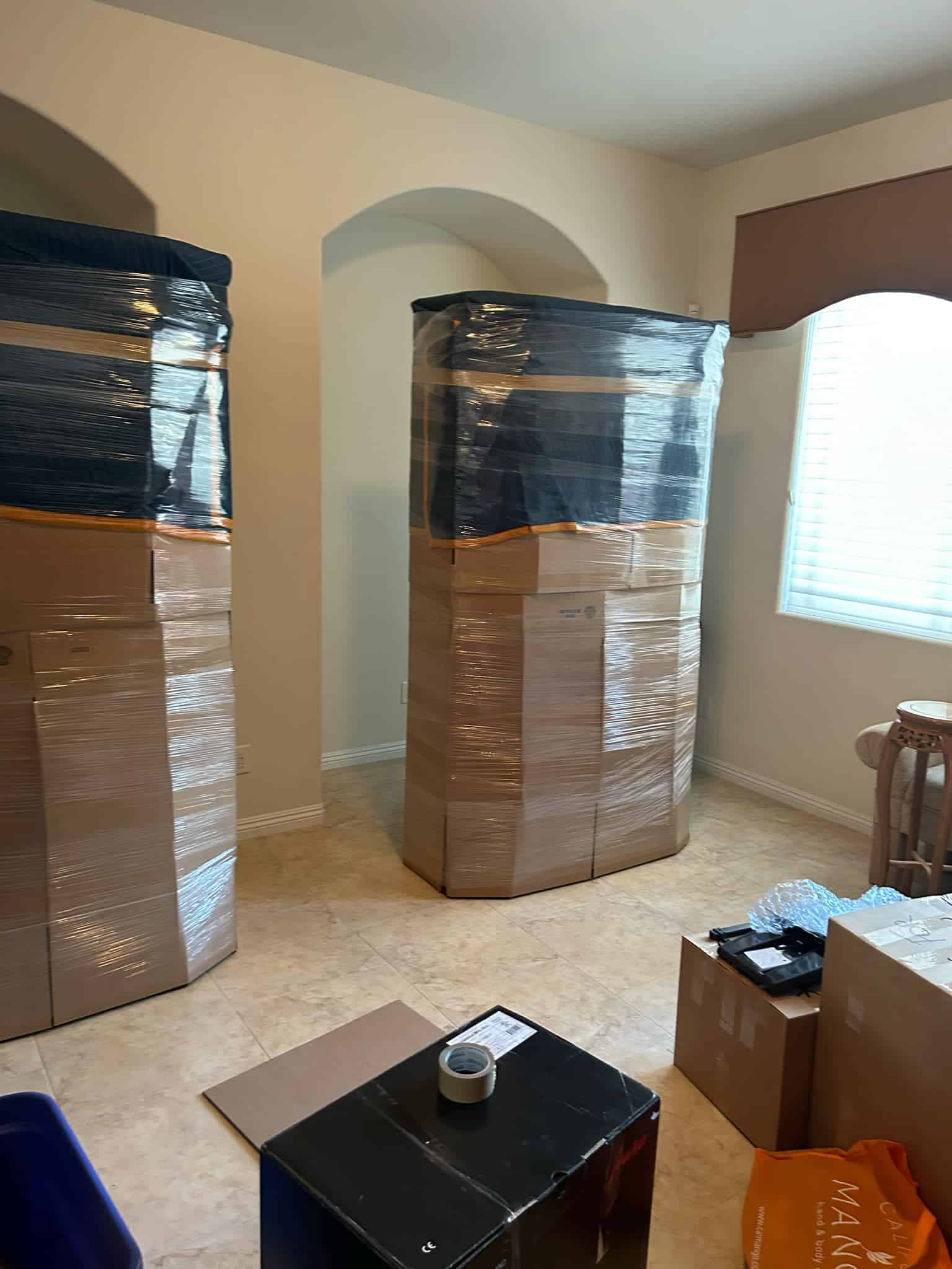 Furniture pad-wrapped and shrink-wrapped in a Las Vegas home ahead of placement.