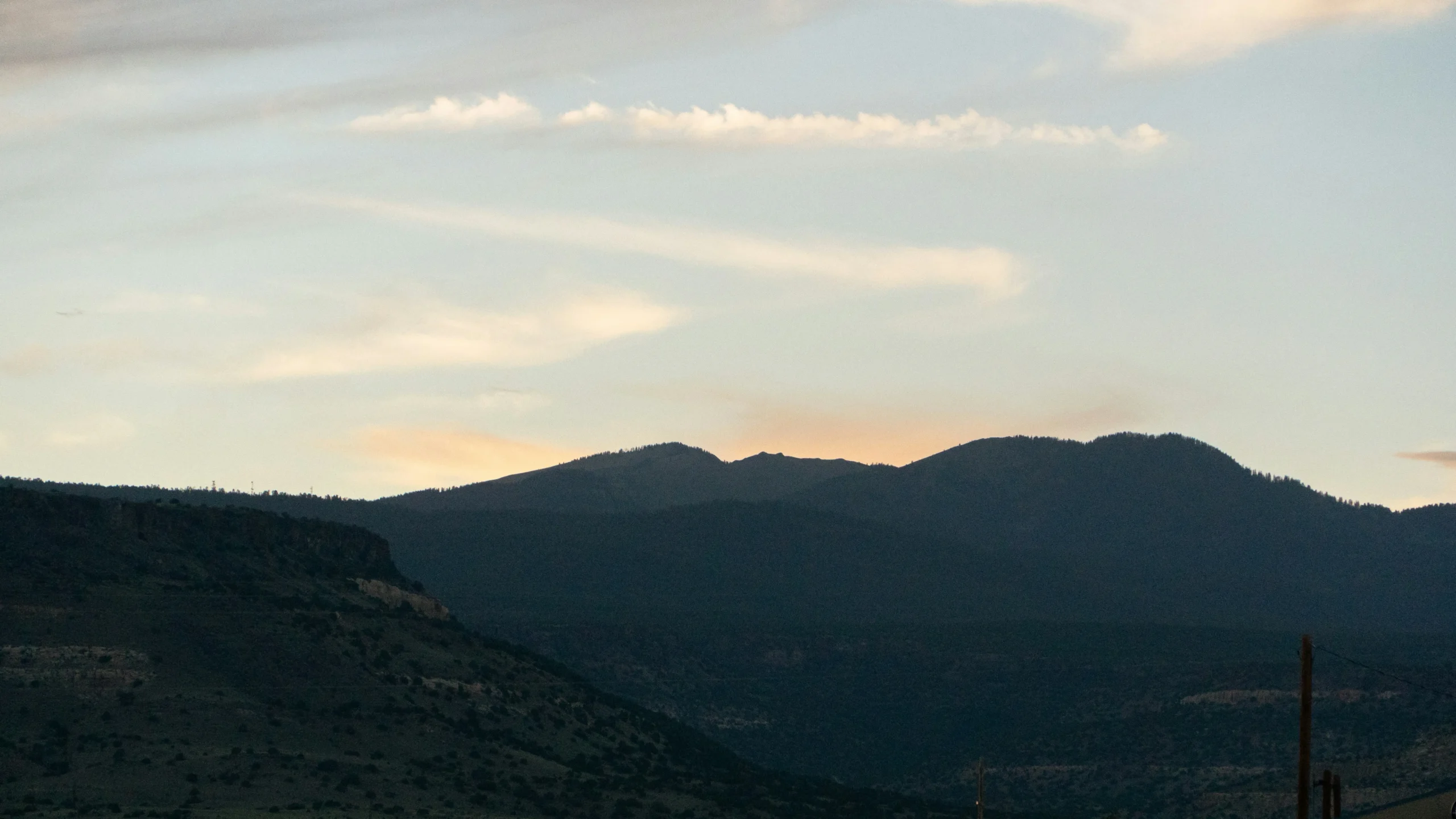A mountain ridgeline silhouetted against the evening sky.