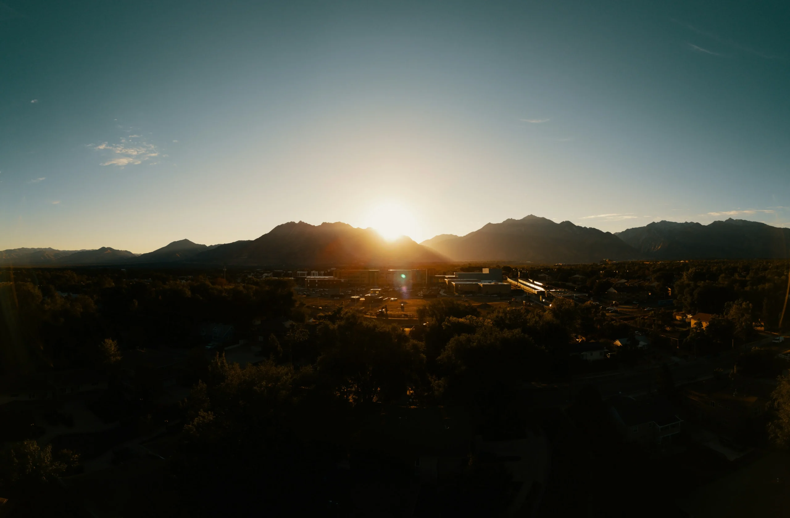 The sun setting behind the mountains at the edge of the valley.
